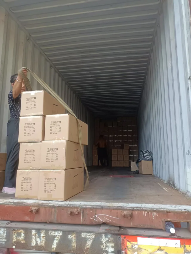 Cartons being strapped and braced inside a loading container at the yard
