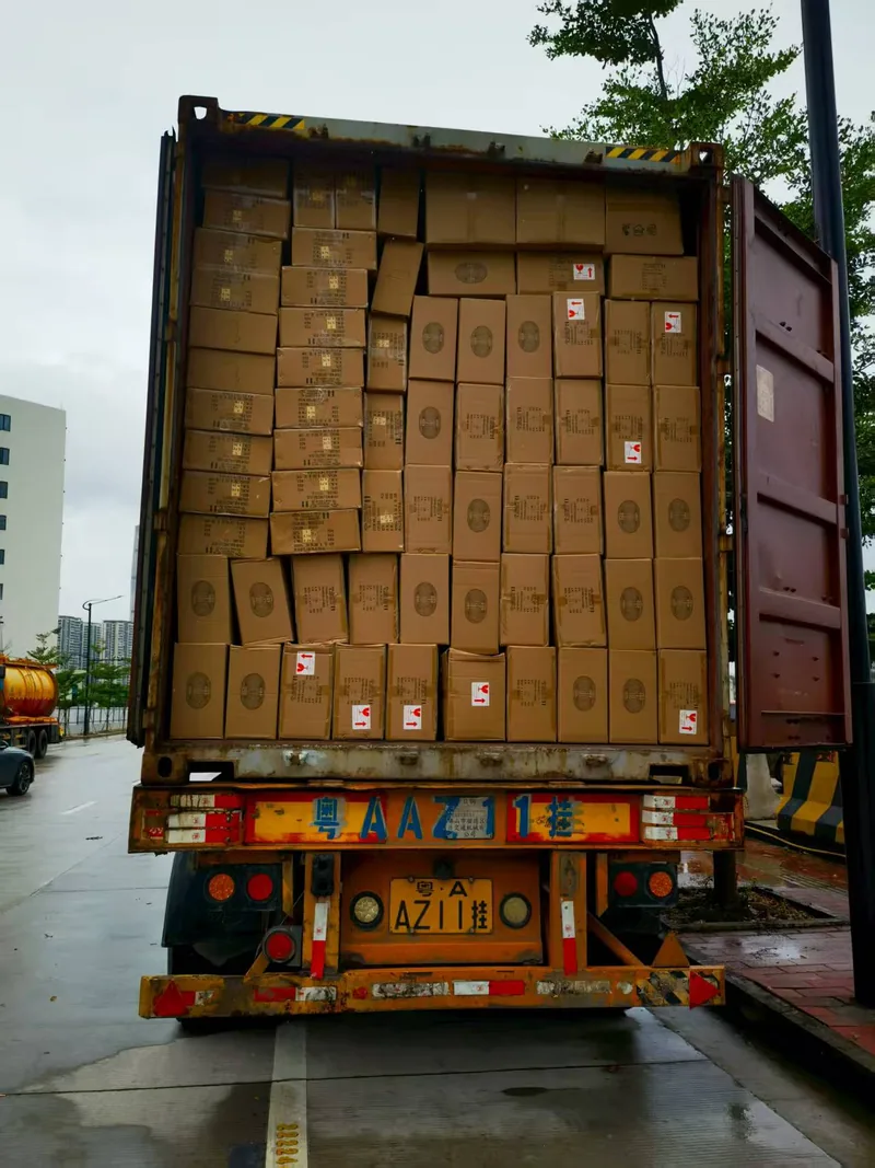 The open front of a red container filled edge to edge with cartons