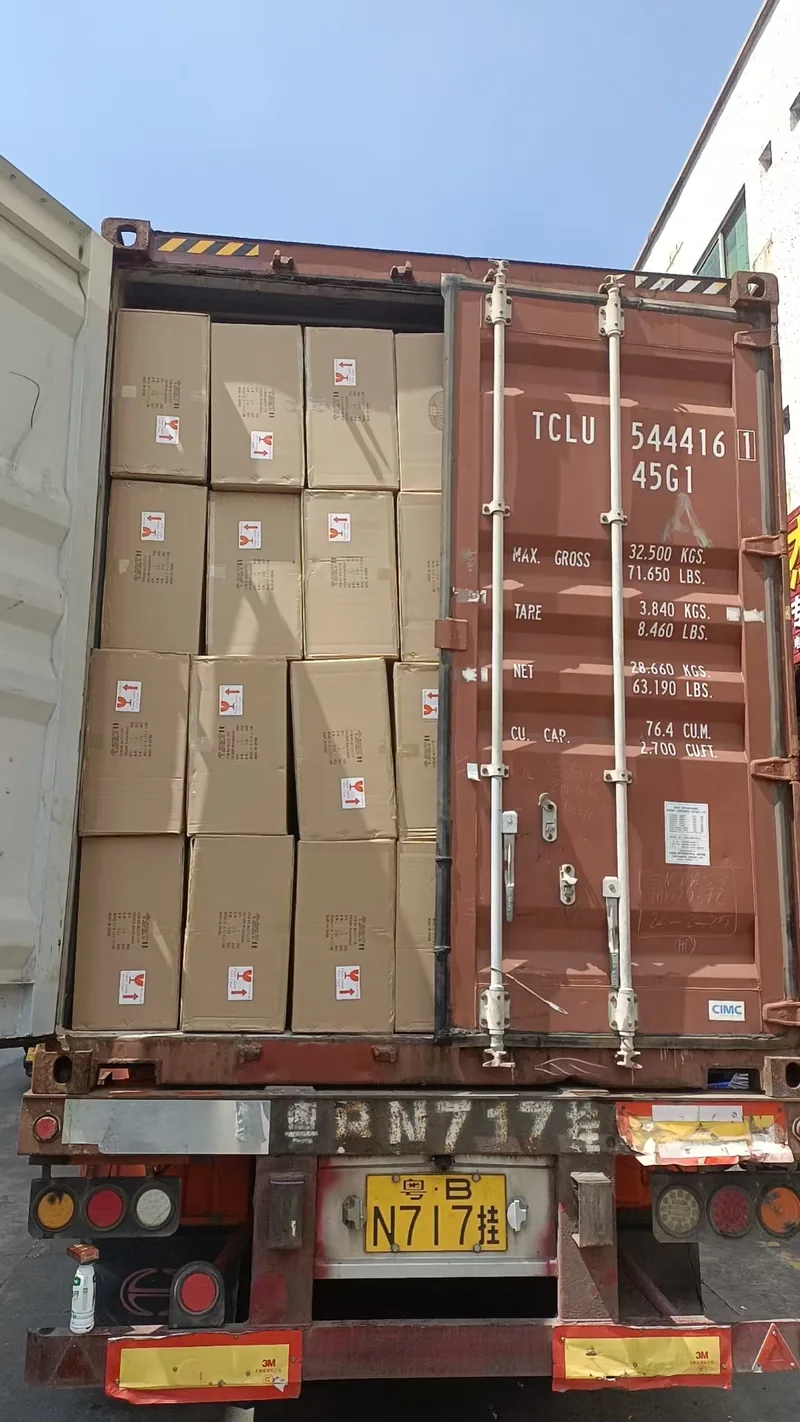 One door of a full container half open, showing the packed carton wall behind it