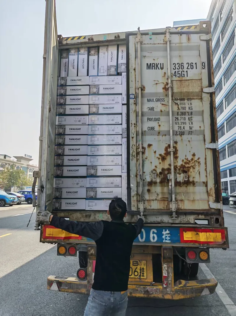 A loader swinging the container doors shut on a finished load of cartons
